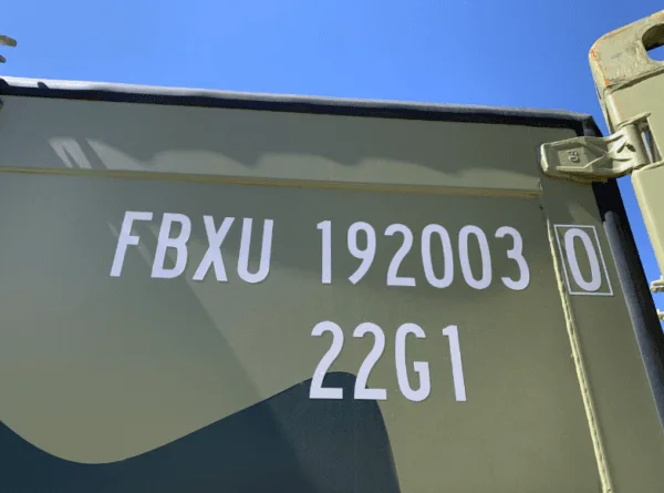 Stencilled owner code and type code on the camouflage paintwork of a container
