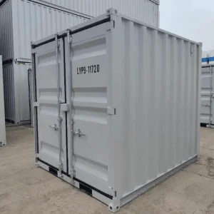 Grey 9ft container with its cargo doors closed inside a storage depot