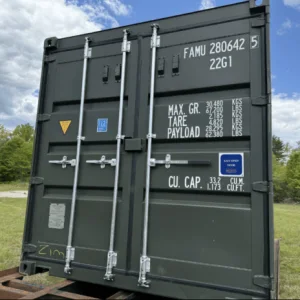 Cargo doors and data panel on a green 20ft container resting on a trailer in a field