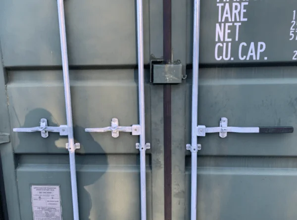 Galvanised locking bars, black lockbox and CSC plate on the doors of a green container