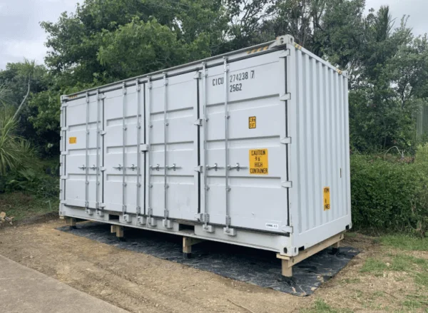 White open side container standing on timber bearers with its side doors closed