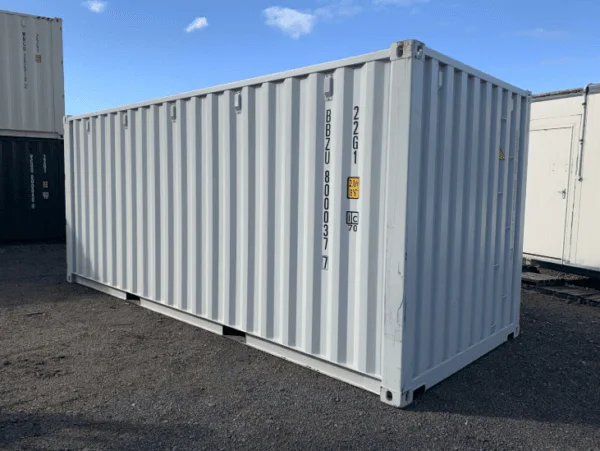 Light grey 20ft container seen along its side wall with its owner code stencilled on