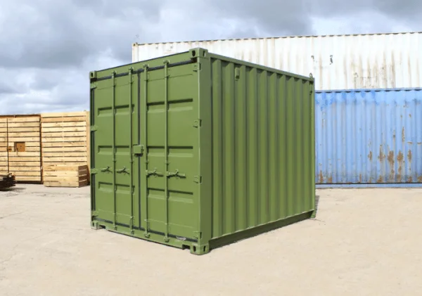 Olive green used 10ft container with S2 doors, parked beside stacked timber pallets