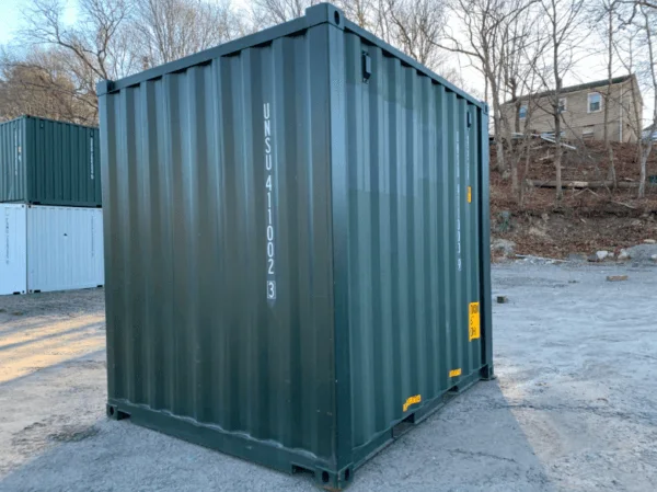 Green 10ft container viewed from its rear corner with other containers in the background