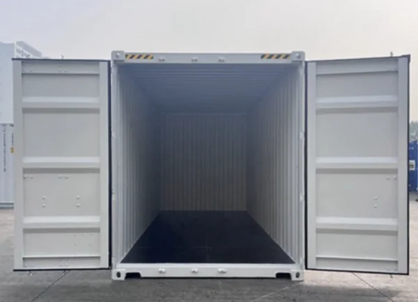 Cargo doors opened at the end of a white container, showing the dark floor inside