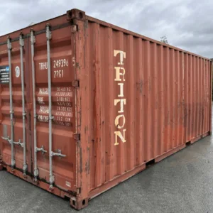 Weathered orange used 20ft container with shipping line lettering on its side