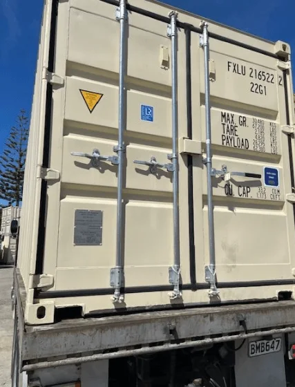 Beige 20ft container on a truck bed, photographed square on to its cargo doors