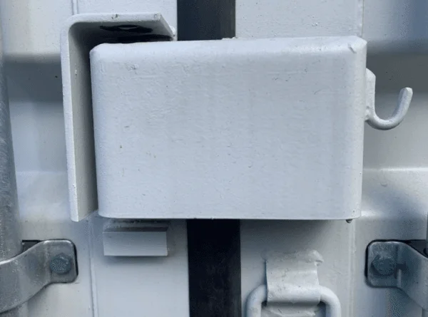 White painted lockbox fitted over the door handles of a light grey container