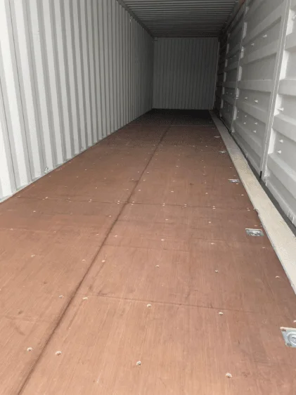 Timber floor running down the inside of a beige 40ft container