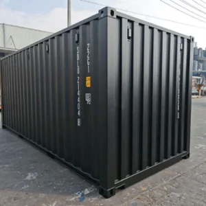Black 20ft one trip container standing on a factory yard, seen from the corner