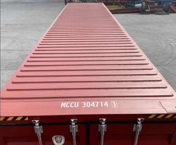 Ribbed roof of a dark red container seen in perspective from the door end