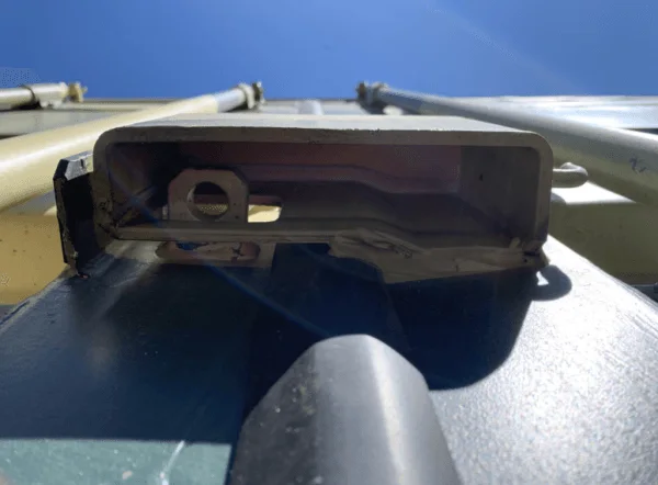 Close-up of a lifting fitting on the top rail of a container against the sky