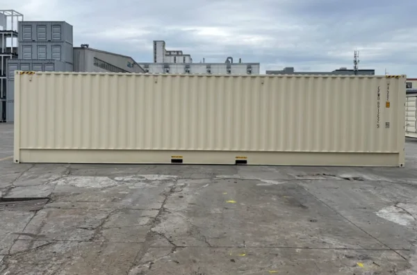 Plain corrugated side of a beige 40ft high cube container on a factory yard