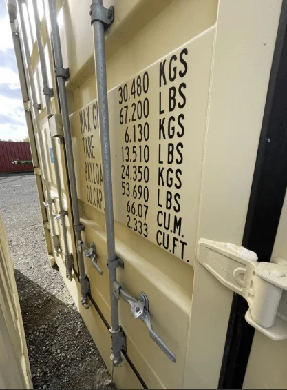 Weight markings and door handle on the corner of a beige container