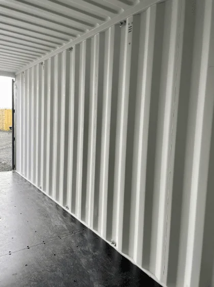 Inside a container looking along the ribbed wall to the daylight at the doors