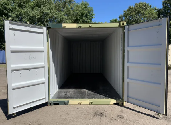 Camouflage painted 20ft container with both doors open on a sunny yard