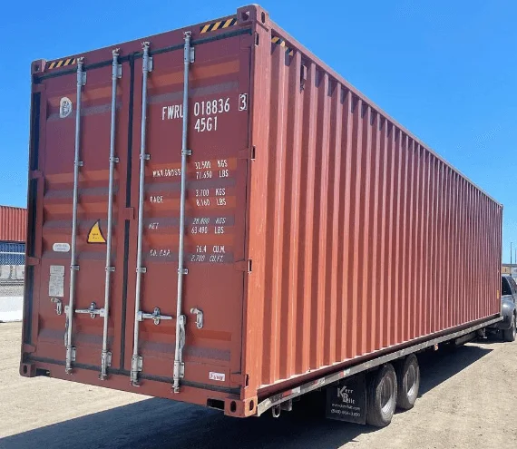 Red open side 40ft container loaded on a trailer with its side doors closed