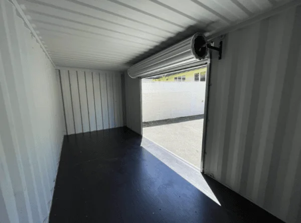 Container interior lit through the open roller shutter with the drum overhead