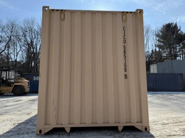 End wall of a beige high cube container standing in winter sunshine