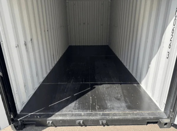 Open container doors showing the dark painted floor and pale ribbed walls inside