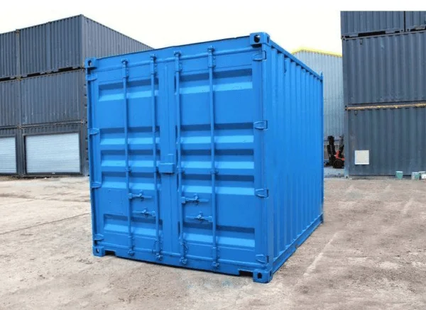 Blue 8ft storage container seen from the door corner on a concrete yard