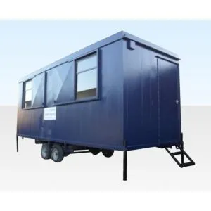 Blue towable canteen cabin on a twin axle chassis with windows along one side
