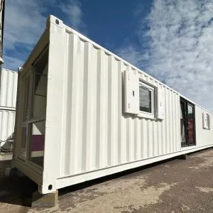 Long white container building with windows fitted along one side