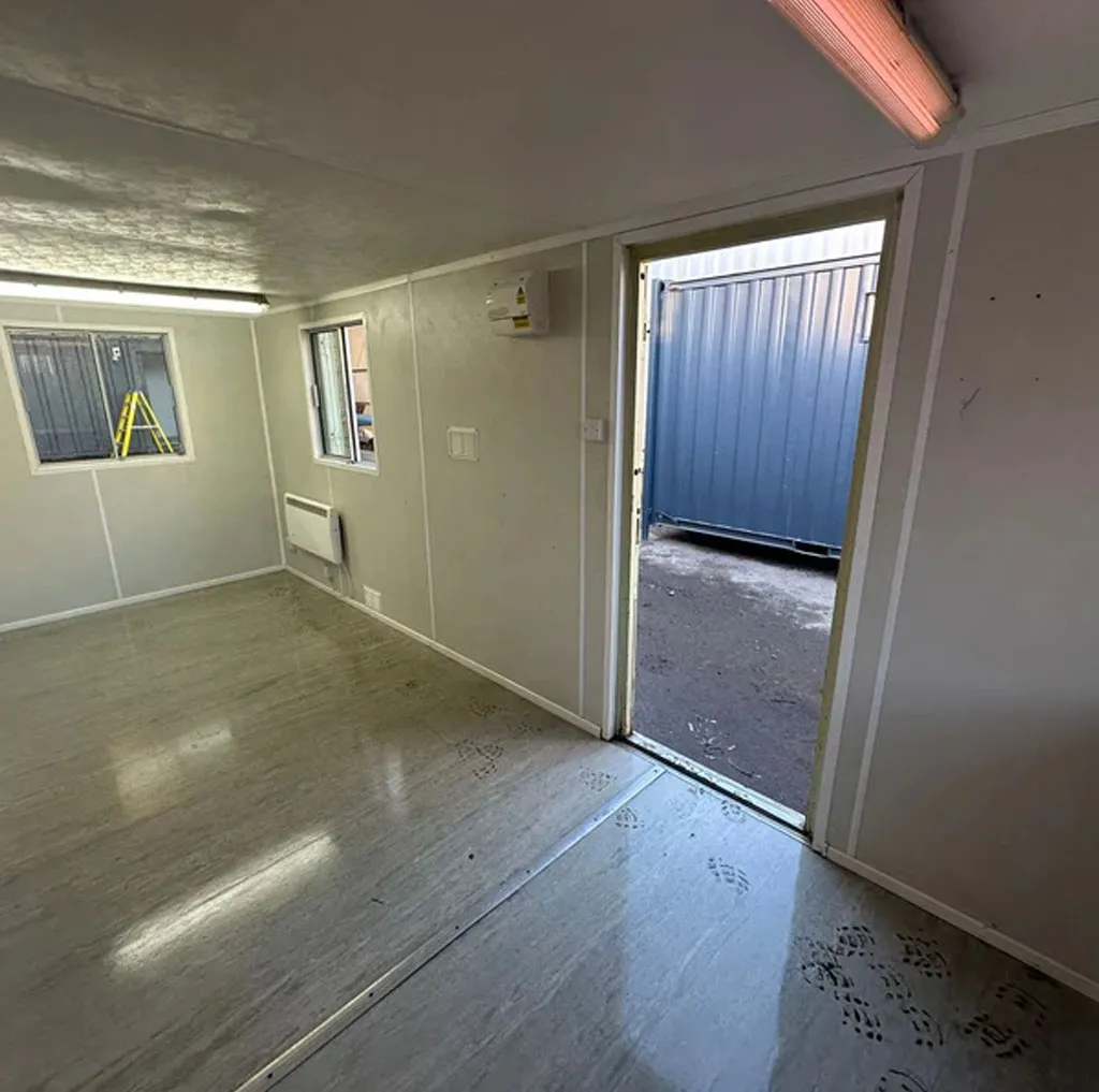 Inside a container office looking out through the open anti-vandal door