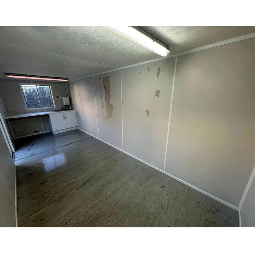 Cabin interior fitted with base units and a worktop beneath a shuttered window