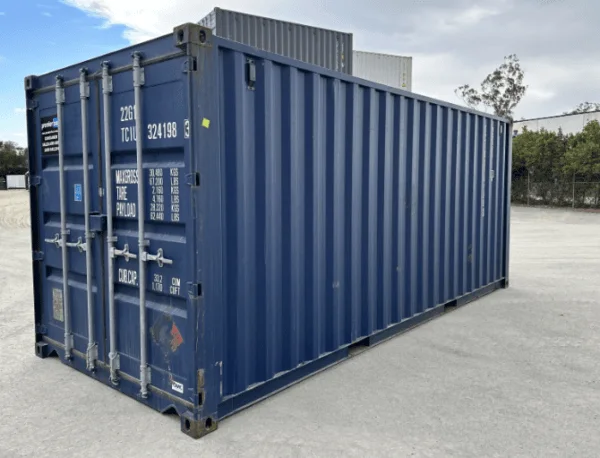 Dark blue 20ft container with double doors, seen from the corner on a concrete yard