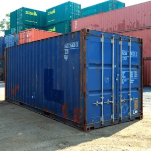 Blue used 20ft container in a depot with stacked coloured containers behind