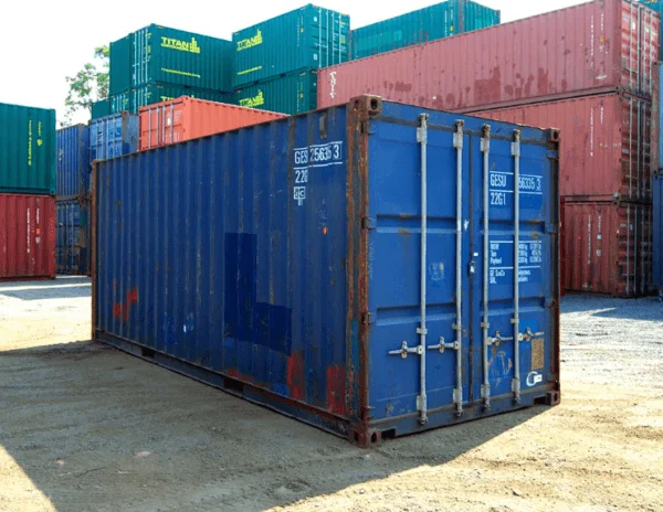 Blue used 20ft container in a depot with stacked coloured containers behind