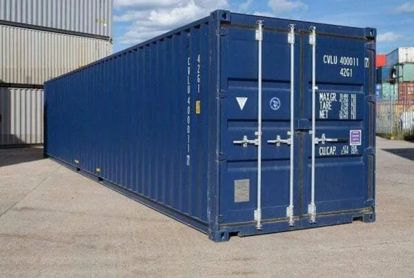 Dark blue 40ft high cube container seen from the door corner in bright sun