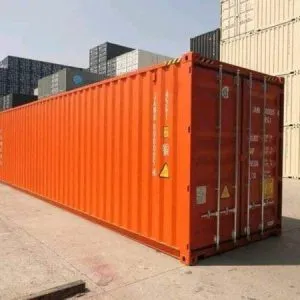 Orange used 40ft container standing among stacks at a container depot