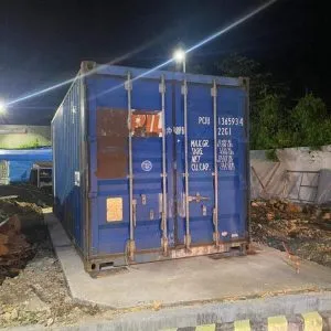 Blue used 40ft container photographed at night under a floodlight