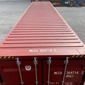 Looking along the ribbed roof of a dark red 40ft container from the doors