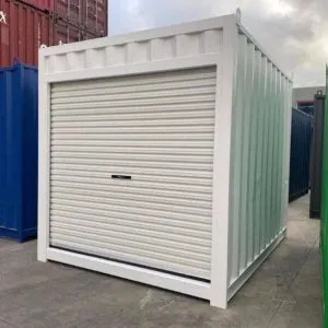 Pale green 10ft container fitted with a white roller shutter door, standing in a container yard