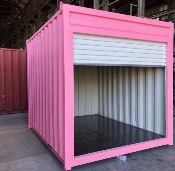 Bright pink container with its white roller shutter raised, showing the empty painted interior
