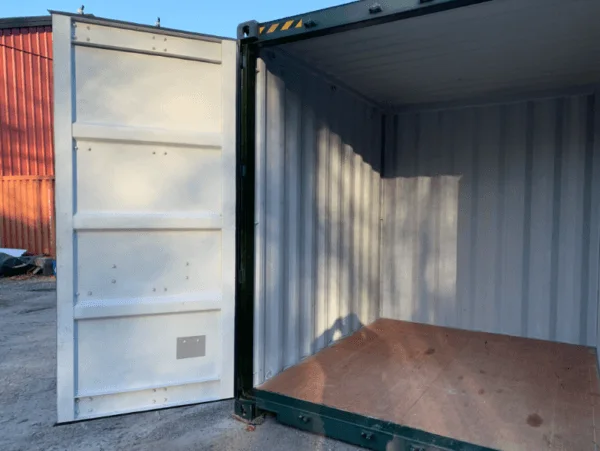 Open doors on a green 10ft container with an orange container standing behind it